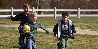 three-boys-playing-with-ball-in-field